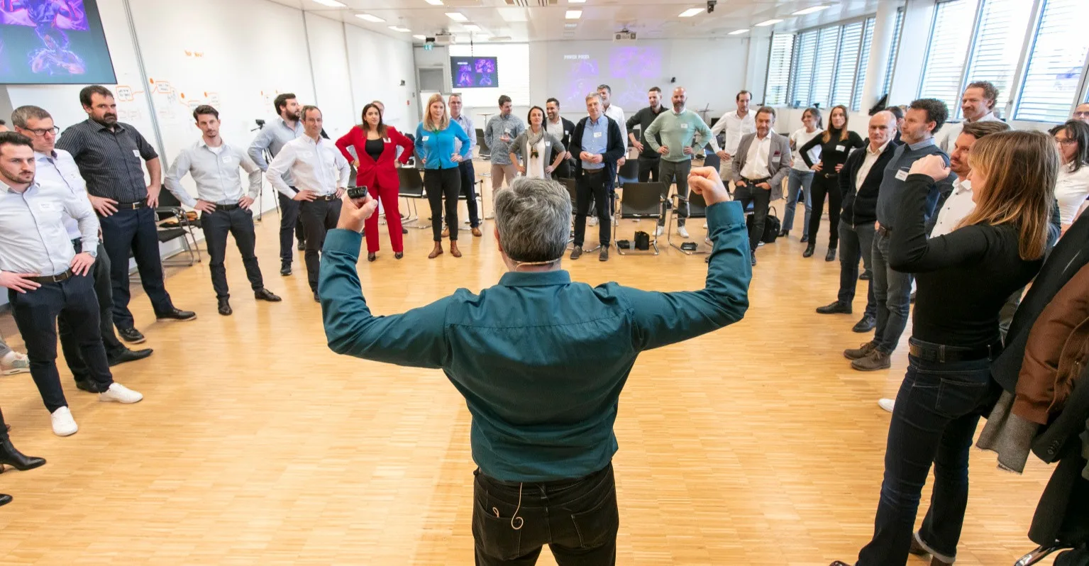 Damien Gauthier leading a large group in a corporate communication training